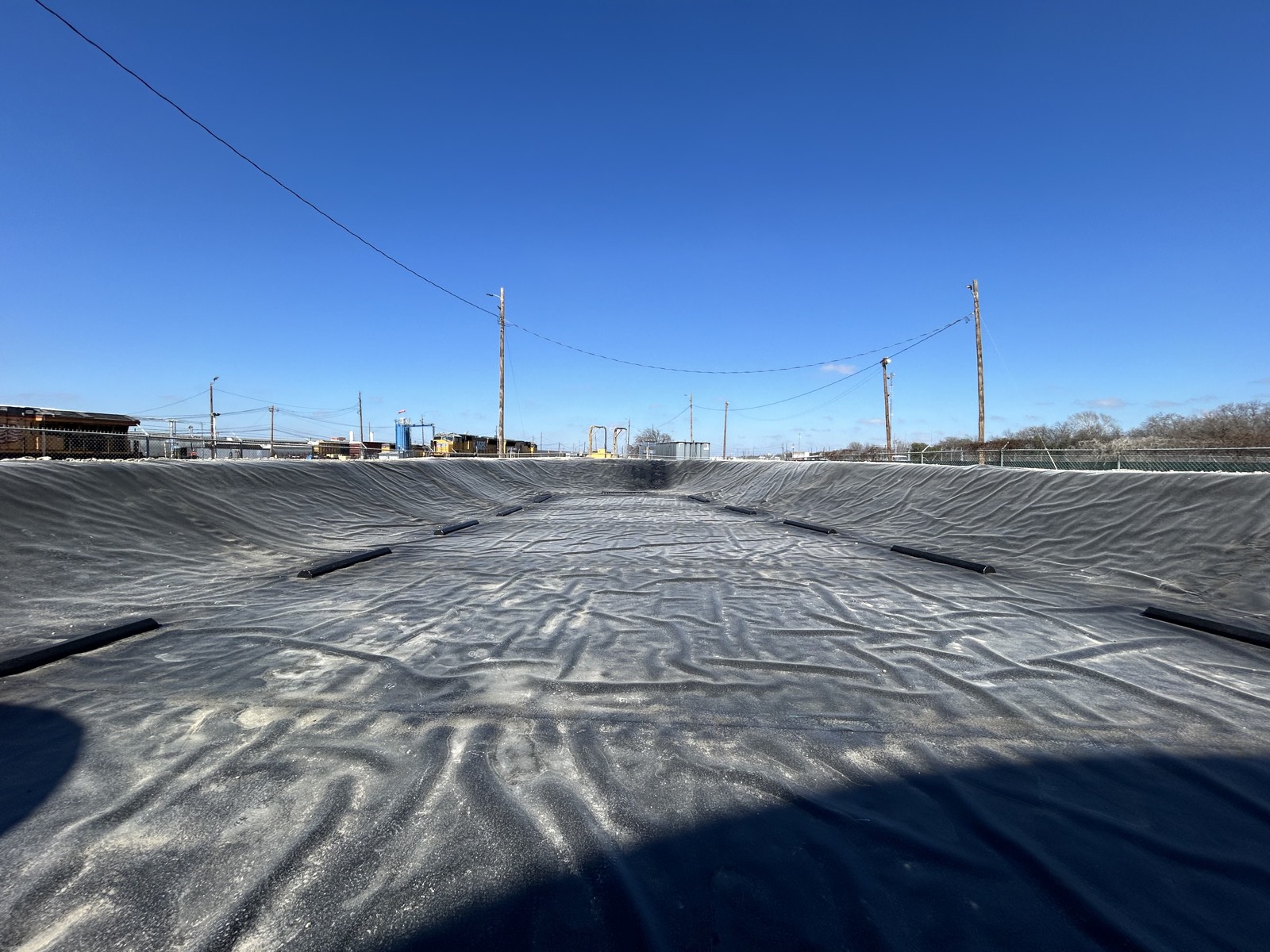 Completed prefabricated containment liner across a 35,000 sq ft diesel storage basin