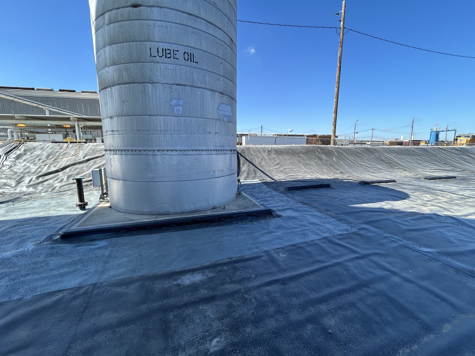 Completed liner and seam treatment detailed around a lube-oil tank foundation and adjacent drain