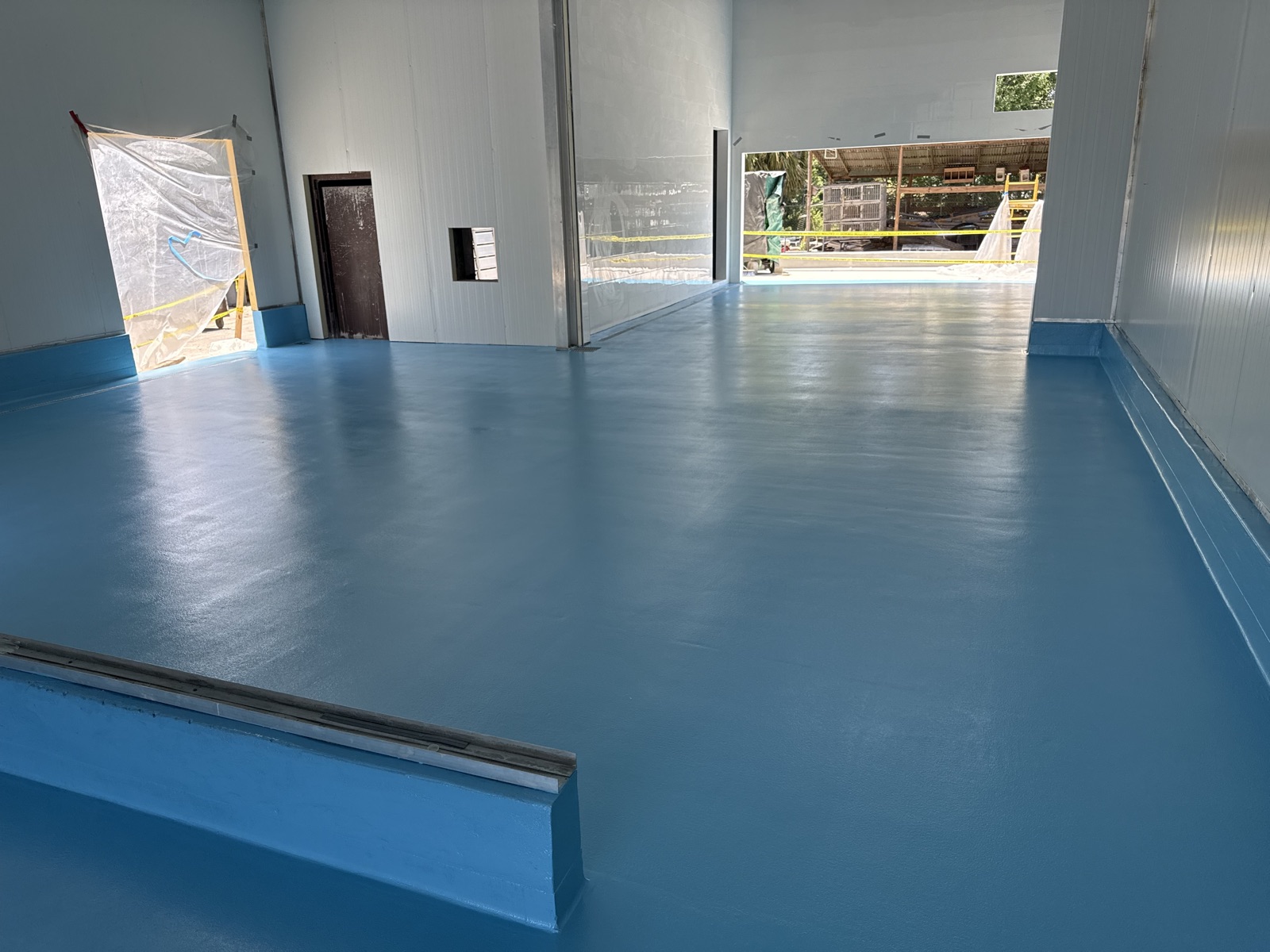 Poly slurry broadcast floor in a meat market cooler with integral cove base